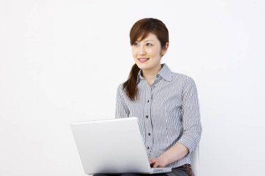 Dizüstü bilgisayarı olan genç Asyalı bir kadın. 