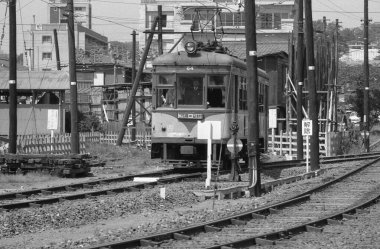 Şehir merkezindeki tren şoförünün siyah-beyaz görüntüsü.
