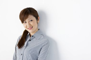 Asyalı genç bir kadın izole edilmiş arka planda gülümsüyor. 