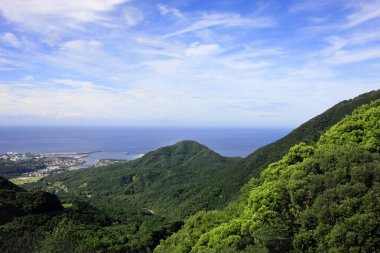 Mavi arkaplan üzerinde yeşil dağların manzarası 