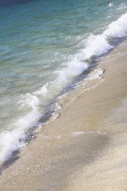 Deniz dalgaları kumlu sahile çarpıyor. seyahat, tatil kavramı