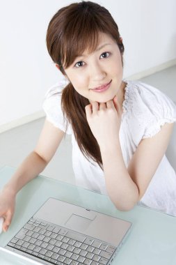 Evde dizüstü bilgisayarla çalışan genç bir kadın.