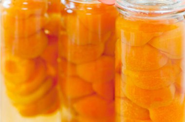 Kayısı dilimleri, cam kavanozları sıkıca doldurur.