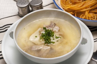 Makarna tabağının yanında otlu buharlı çorba.