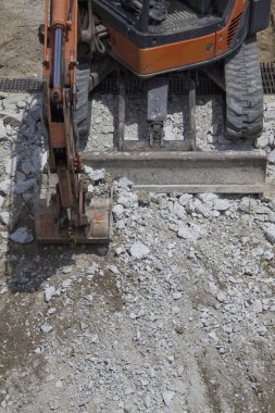 Yol kazıcı inşaat alanında çakıllarla çalışıyor..