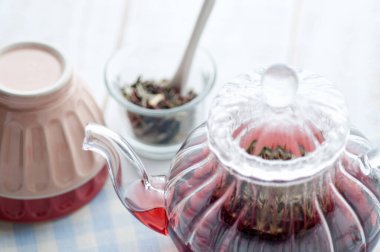 Masada çiçekler olan bir fincan bitki çayı.