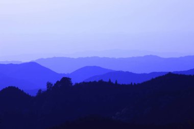 Dağları ve mavi gökyüzü olan güzel bir manzara.