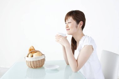 Asyalı kadın kahvaltısını evde yapıyor. 