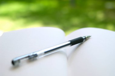 close-up view of pen lie on the white notebook