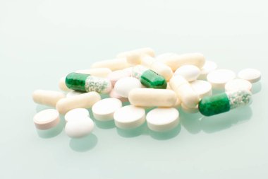 Beyaz arkaplanda yeşil ve beyaz haplar 