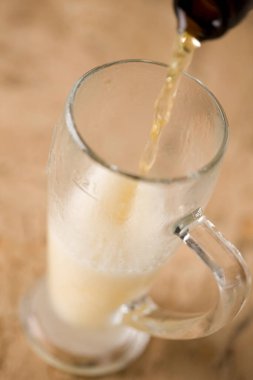 Soğuk birayı cam bardağa döküyorum.