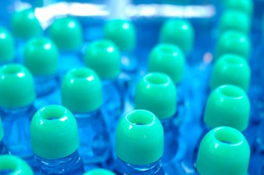 many blue bottles with liquid on blue the background.