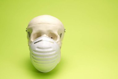 Beyaz tıbbi maskeli insan kafatasının yakın plan görüntüsü    