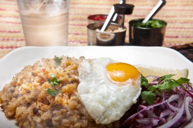 Tabakta kızarmış pirinç ve yumurta ile servis edilen bir tabak.