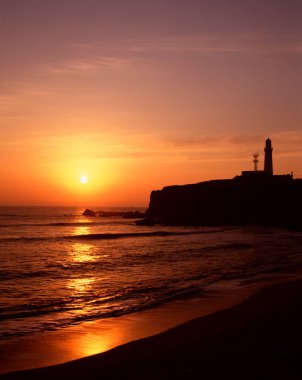 Deniz feneri parlayan gün batımı deniz manzarasının üzerinde dimdik duruyor.. 