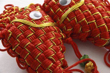 Kırmızı ve altın iplikçiklerden yapılmış Çin balık düğümü