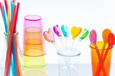 Renkli kalp şekilli çubuklar, bardaklar, pipetler ve kaşıklar.