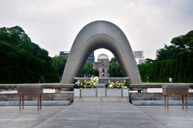 Hiroşima Barış Anıt Parkı 'ndaki Atom Bombası Mağdurları Cenotaph' ı, Hiroşima, Japonya 'da onarılmamış bir hatıra olarak bırakılmış belediye binası manzarası..
