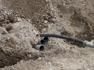 Sert toprak kazma sahasında ortaya çıkan siyah borular.