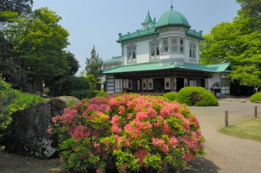 Eski bina ve çalılarla dolu bir Japon parkı.