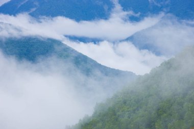 Manzaralı dağların üzerindeki bulutlarla güzel bir manzara.       