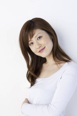 Genç Asyalı kadın beyaz arka planda izole edilmiş kameraya bakıyor. 