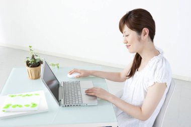 Masada dizüstü bilgisayarda çalışan genç bir kadın. 