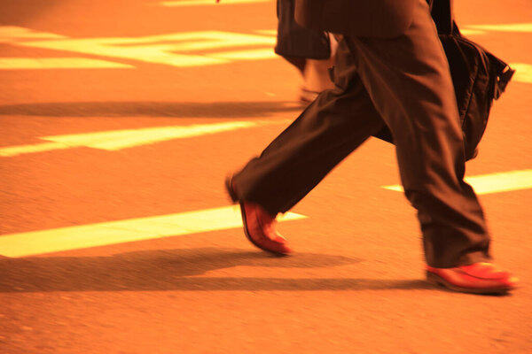 Low section of man in a suit walking on the street