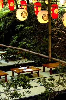 Geleneksel Japon fenerleri açık hava tatami yemek alanının üstünde asılı.