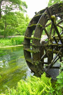 Yazın kırsal alanda manzaralı nehri olan eski ahşap su değirmeni           