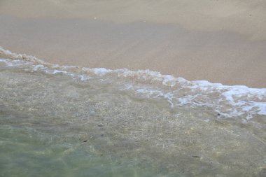 Deniz dalgaları ve kumsalın güzel kumlu kıyıları     