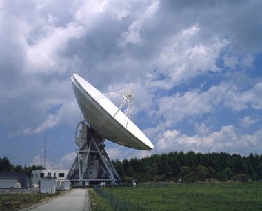 Bulutlu gökyüzünün altında büyük bir uydu anteni