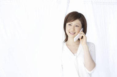 Kadın cep telefonuyla konuşuyor.