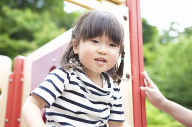 Asyalı küçük kızın portresi oyun alanında eğleniyor.