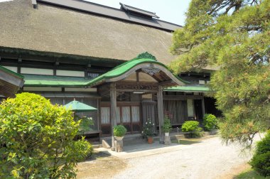 Eski bina ve çalılarla dolu bir Japon parkı.