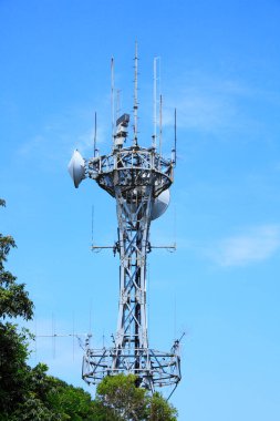 Mavi gökyüzüne karşı telekomünikasyon kulesinin alçak açılı görüntüsü   