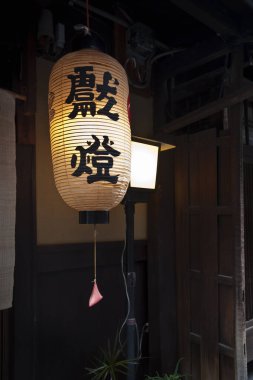 Geleneksel Japon kağıt feneri ahşap kapının yanında asılı.