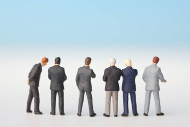 Beyaz arka planda minyatür iş adamları figürleri