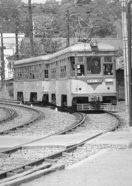 Tren kamarasındaki sürücünün tren raylarında giderken çekilmiş siyah beyaz fotoğrafı. 