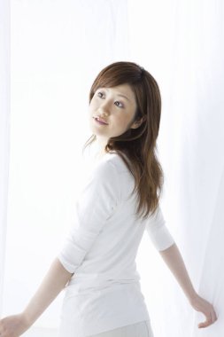 Genç bir kadın oturma odasına bakıyor. 