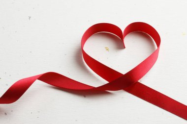 Kırmızı kurdele beyaz arka plan üzerinde kalp şeklinde