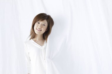 Gülümseyen ve kameraya bakarak Asyalı kadın