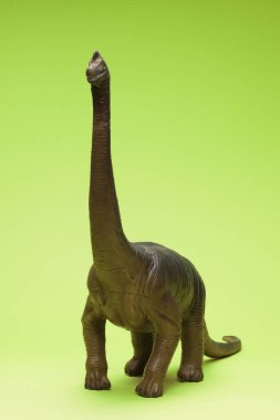 Yeşil arka planda sevimli dinozor oyuncağı                     