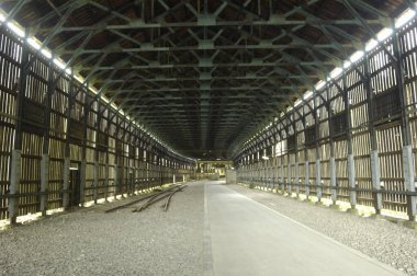 İçinde metal kirişler ve çakıl döşemeleri olan boş sanayi deposu.