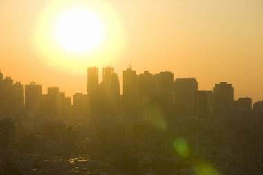 Şehrin üzerinde gün batımı. Gün batımında gökdelenlerin siluetleri