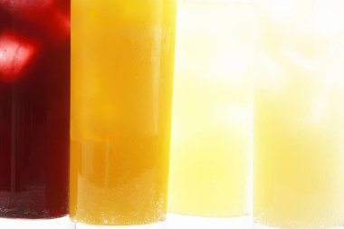 Üç renkli bardak taze meyve suyu, yakın çekim.