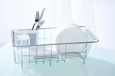 Temiz mutfak masasındaki bulaşık makinesinde temiz tabaklar.