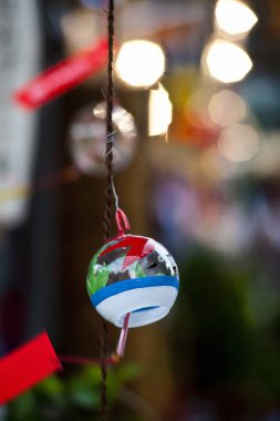Renkli dekoratif çan bulanık arka plan ışıklarıyla asılı