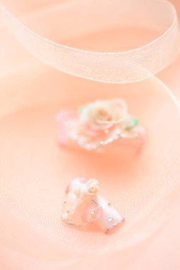 Pembe arka planda çiçek ve kristallerle süslenmiş sahte çiviler.