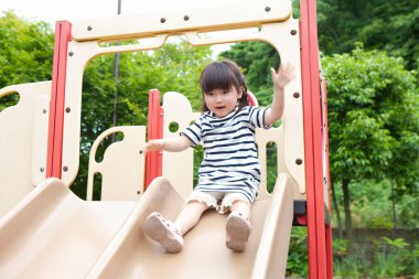 Asyalı küçük kızın portresi oyun alanında eğleniyor.